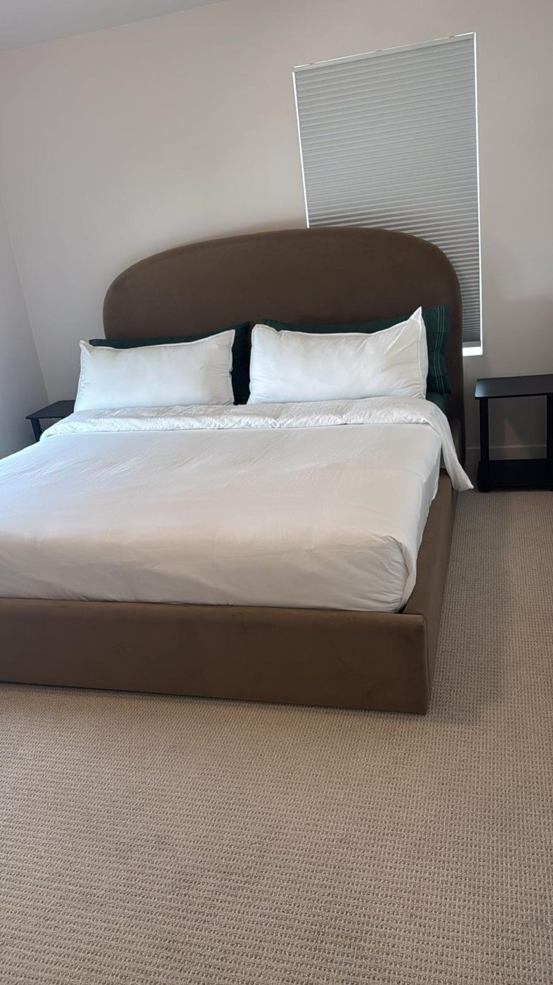 Guest bedroom cleaned and made up with fresh white linens, clean nightstands, and vacuumed carpet