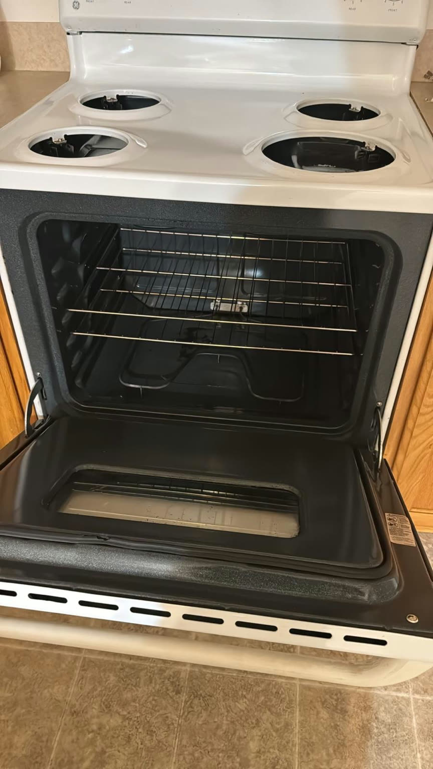 Oven interior after cleaning, with a clean black cavity, degreased door, and bright racks