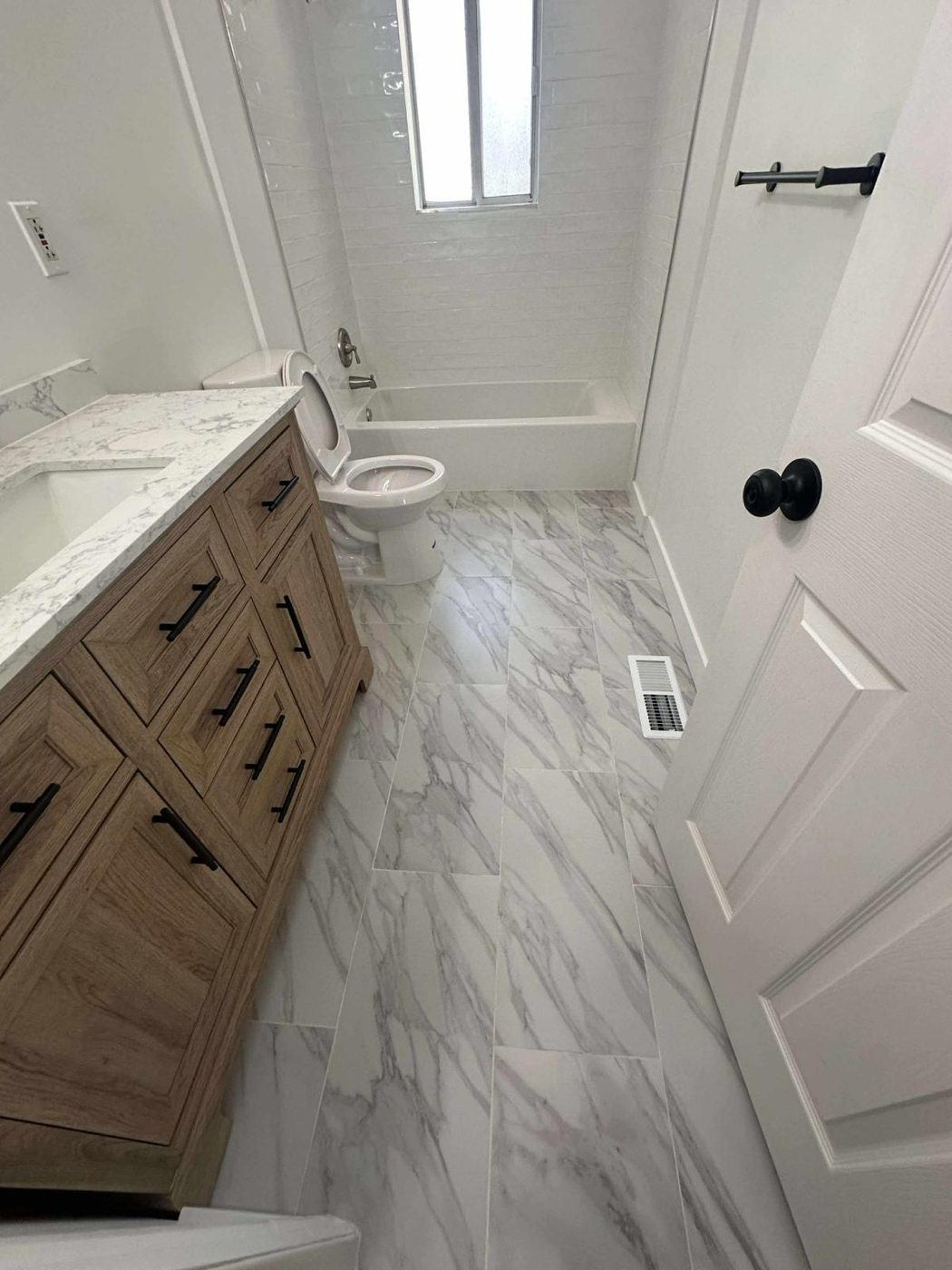 Sanitized bathroom with a spotless tub and tile surround, polished marble-look floor, clean toilet, and streak-free vanity counter