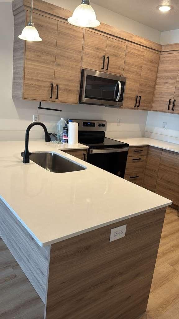 Cleaned kitchen countertop, stainless sink, and wood-tone cabinets with a streak-free finish